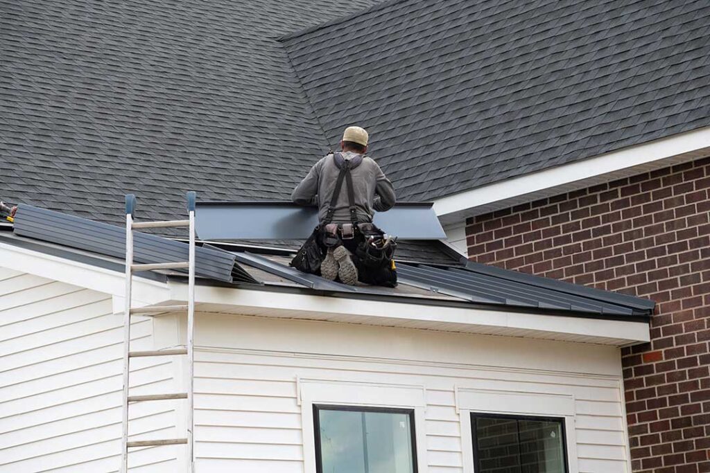 Rainwater flows from roof gutters through a downspout while a homeowner inspects the roof edge.